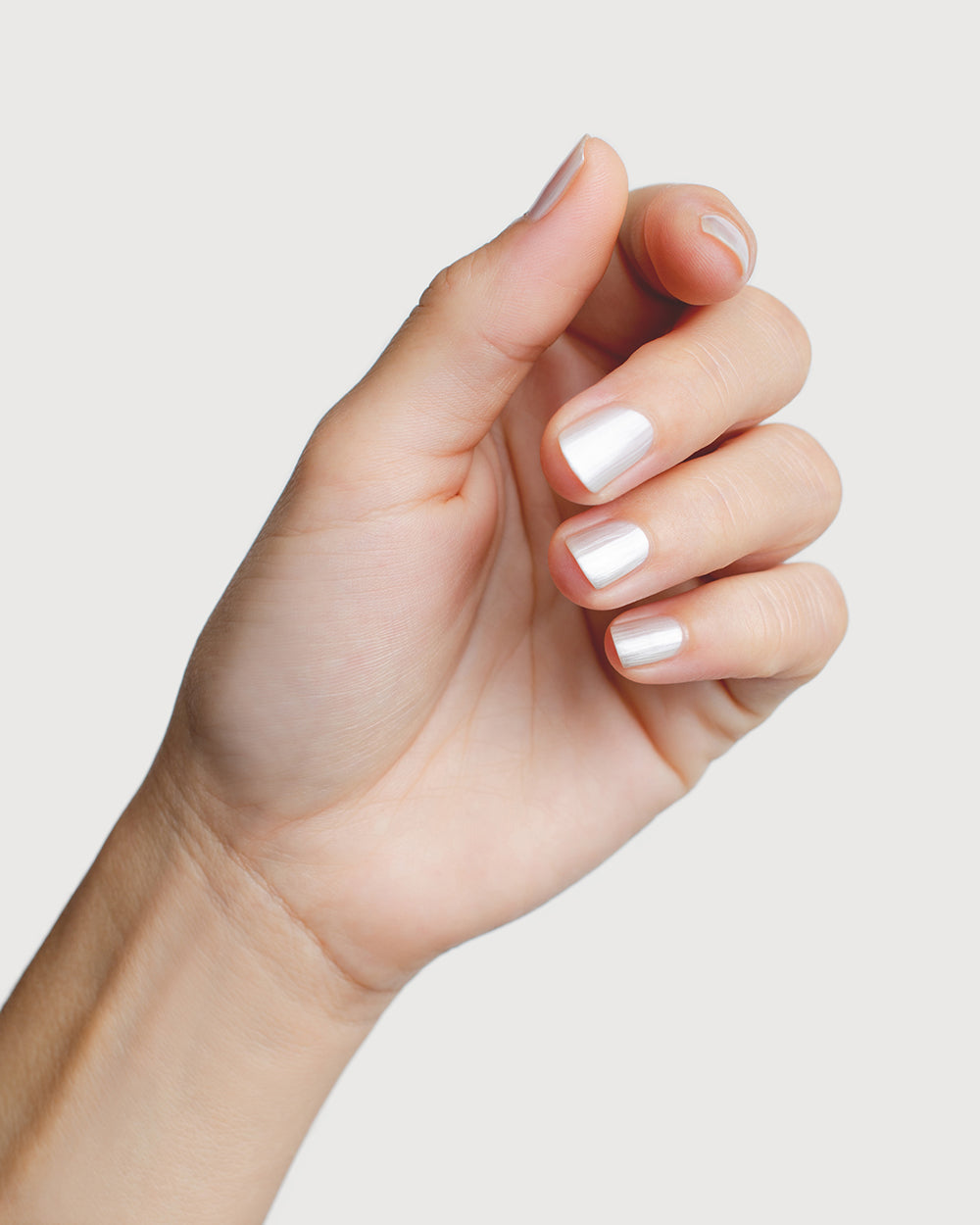 white pearl glazed nail polish hand swatch on fair skin tone