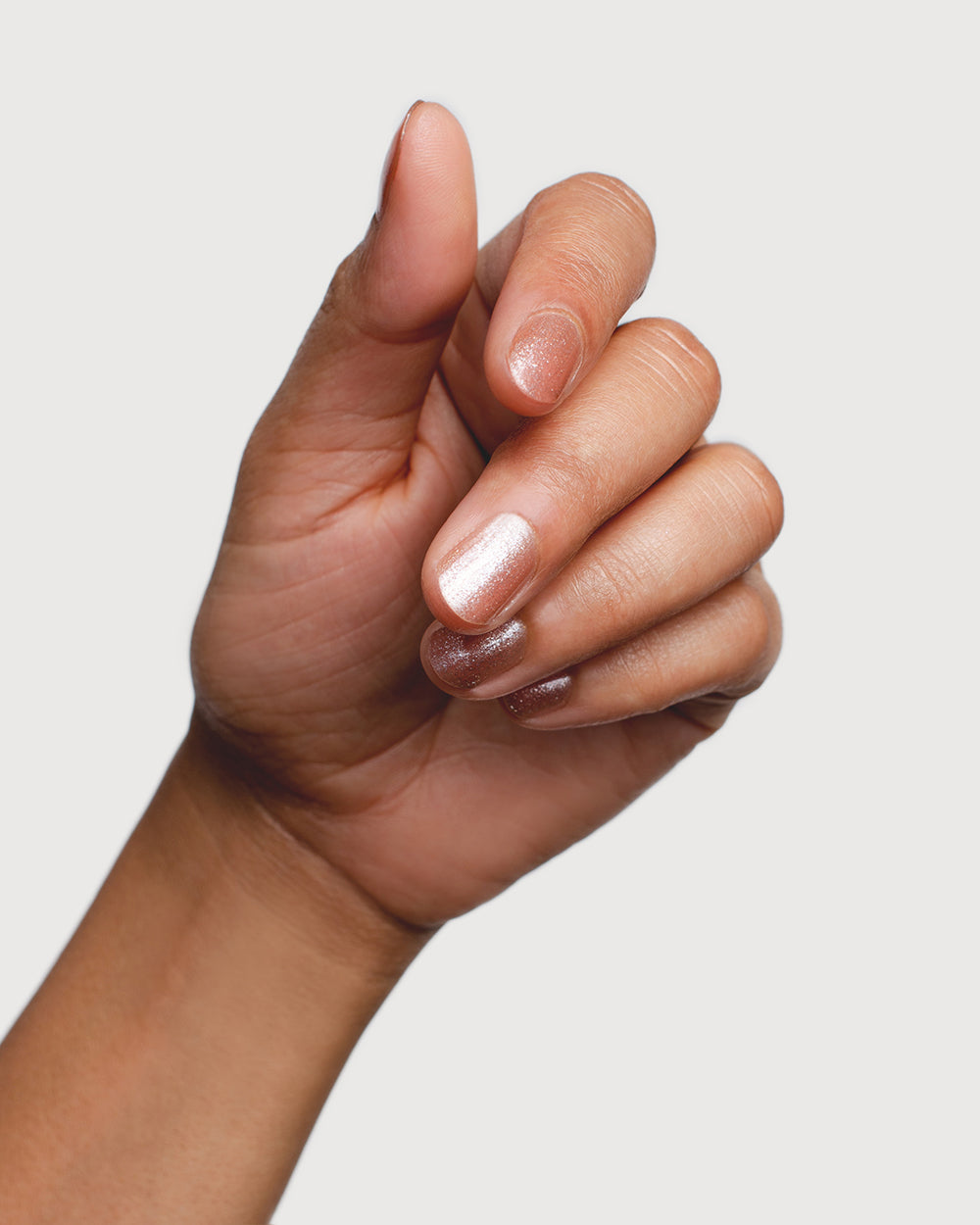 Radiant Rose Peach Crystal nail polish hand swatch on medium skin tone