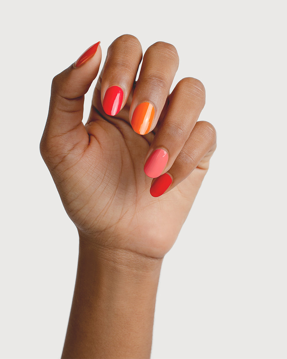 bright pink and orange nail polish hand swatch on medium skin tone by sienna byron bay