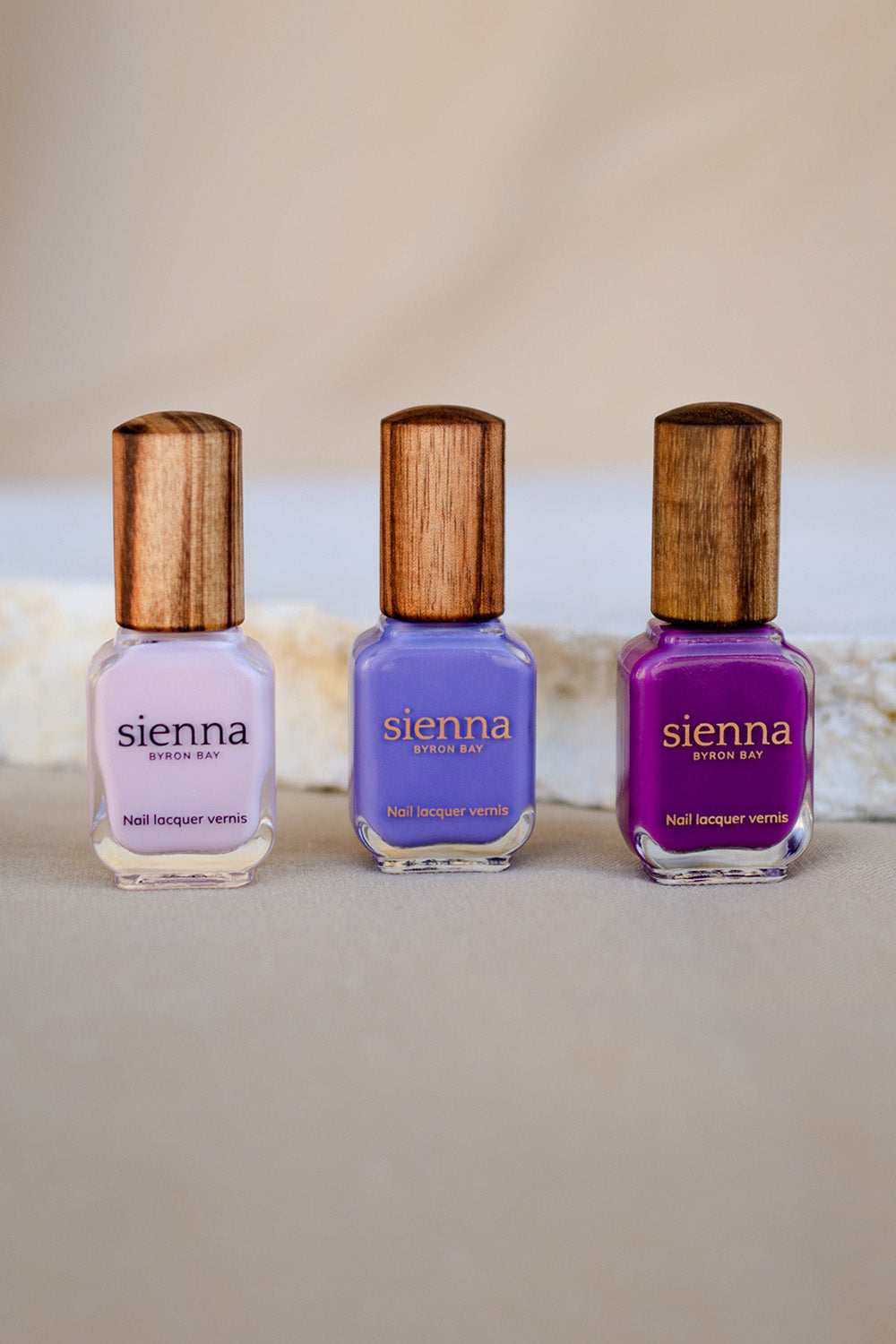 Gentle Blue Lilac Crème nail polish by Sienna Byron Bay on medium skin tone hand holding bottle with timber lid.