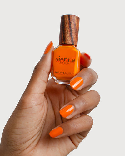 Bright papaya orange nail polish swatch on medium Skin tone by Sienna Byron Bay