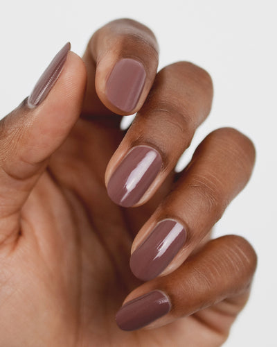 Medium tanned skin hand wearing Grounded mylk chocolate crème nail polish by Sienna Byron Bay close-up