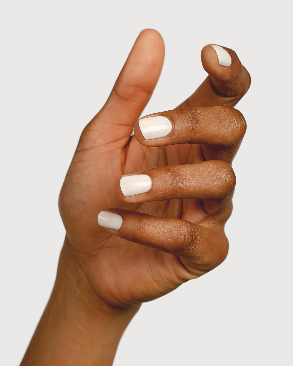 Eggshell white nail polish hand swatch on medium skin tone