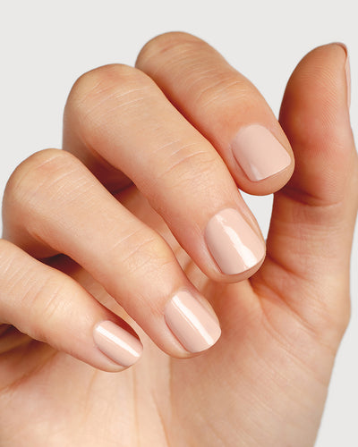 soft neutral-pink nail polish hand swatch on fair skin tone up close