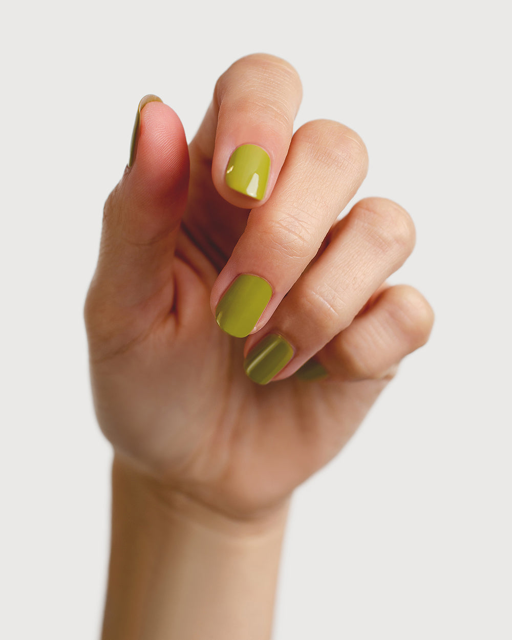 Avocado green nail polish hand swatch on fair skin tone