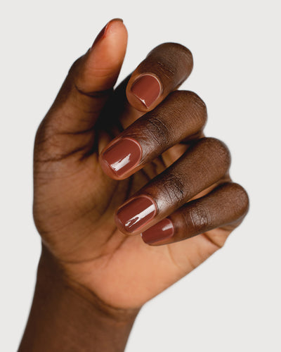 brown nail polish hand swatch on dark skin tone