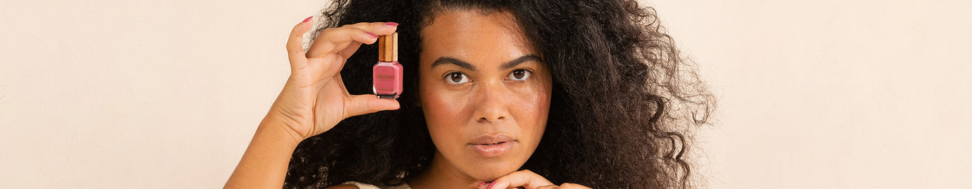 Woman with medium skin and freckles wearing Heartspace raspberry sorbet nail polish by Sienna Byron Bay