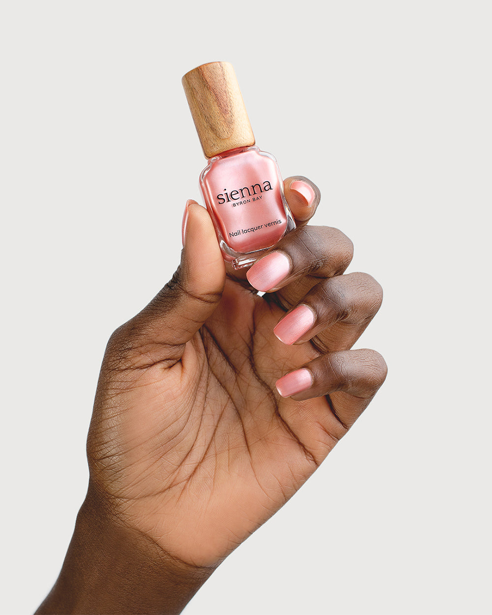 Warm Pink Satin Nail Polish on Dark Skin Tone with Glass Bottle 