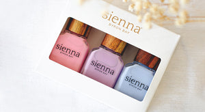 pastel pink purple and blue nail polish bottles in white cardboard box by sienna