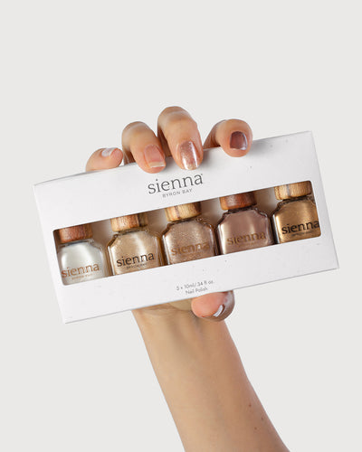 Fair Skin Tone hand holding the cosmic dreams collection pack with painted nails