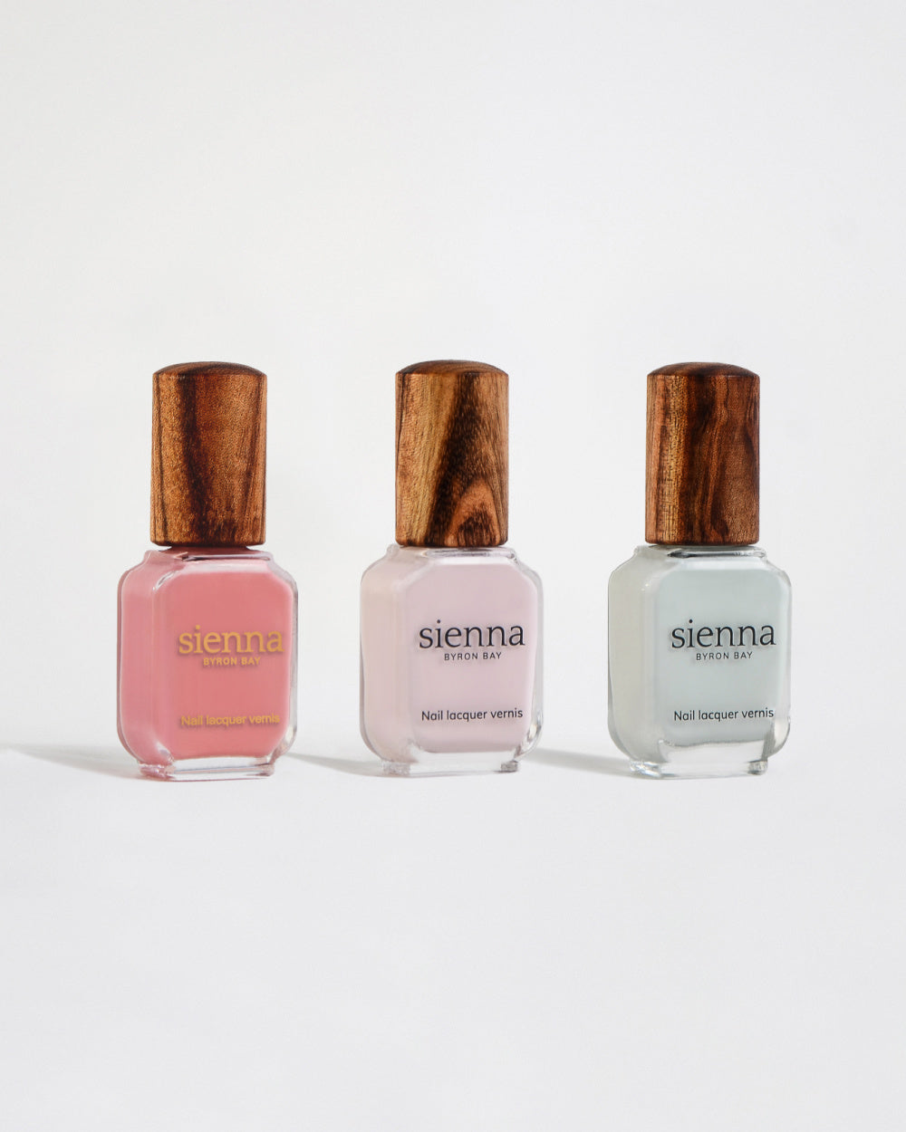 three spring nail polish colours in bottles with a timber lid