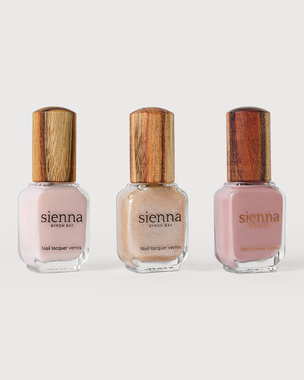 light rosewater pink sheer, Grapefruit Granita Crystal and Dusty rose nail polish bottles with timber caps