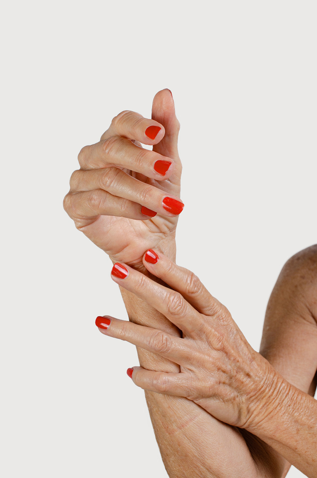 Fair skin tone hands with natural nail polish endearment a rich orange red creme glaze