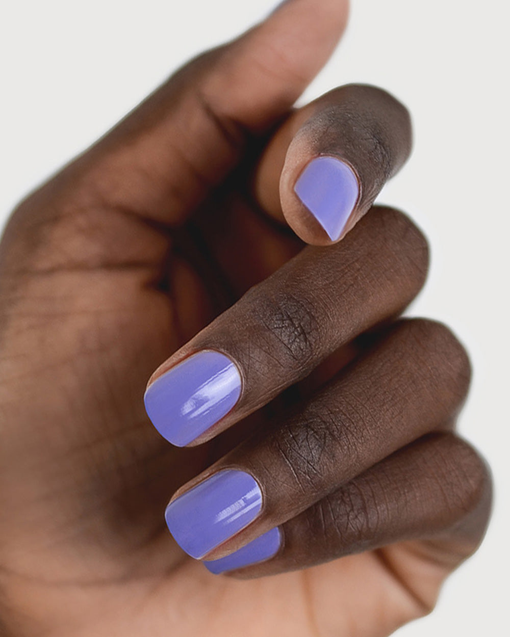 Gentle Midtone Blue Lilac Crème nail polish by Sienna Byron Bay on dark skin tone hand.