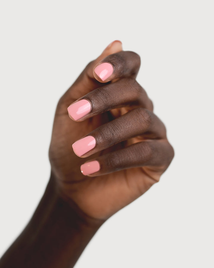 peachy pink nail polish hand swatch on dark skin tone