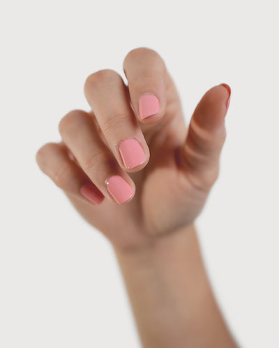 eachy pink nail polish hand swatch on fair skin tone