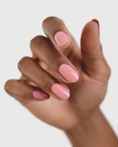 eachy pink nail polish hand swatch on medium skin tone