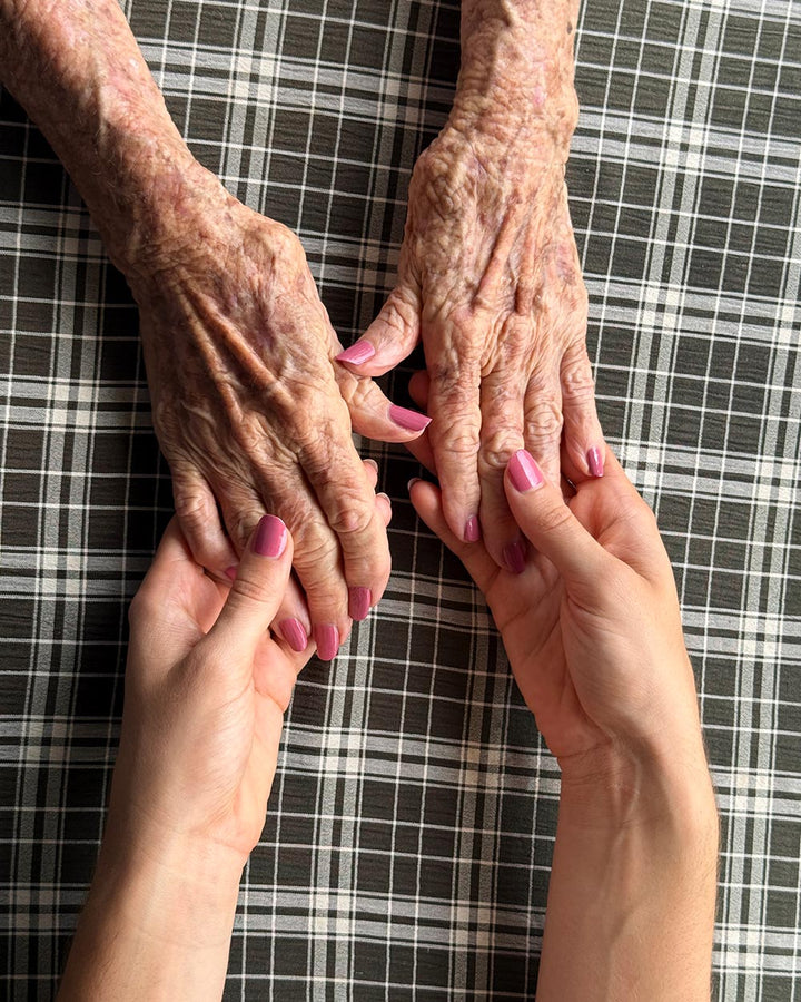 Holding hands with Grandma, both fair hands wearing Blossom nail colour in a soft earthy pink. Grandma&