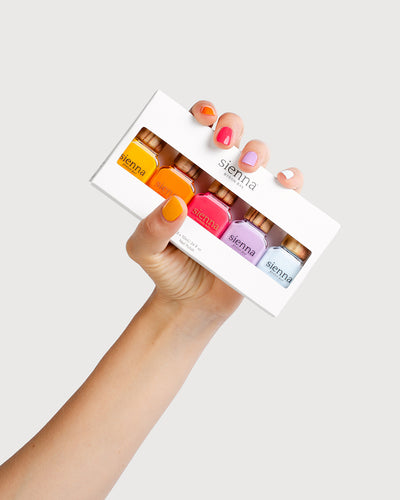 Fair Skin Tone hand holding the Happiness Quin Pack with painted nails
