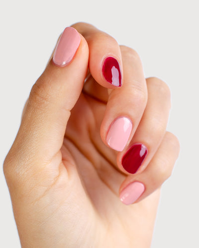 Cherry Blossom Crème and Plum red nail polish on fair skin tone