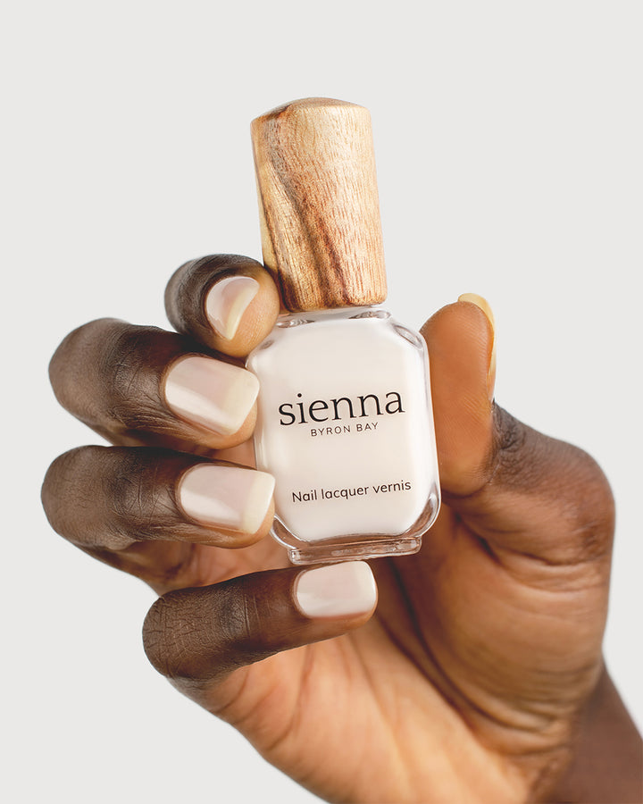 Milky Sheer White nail polish on dark skin tone with Sienna Bottle