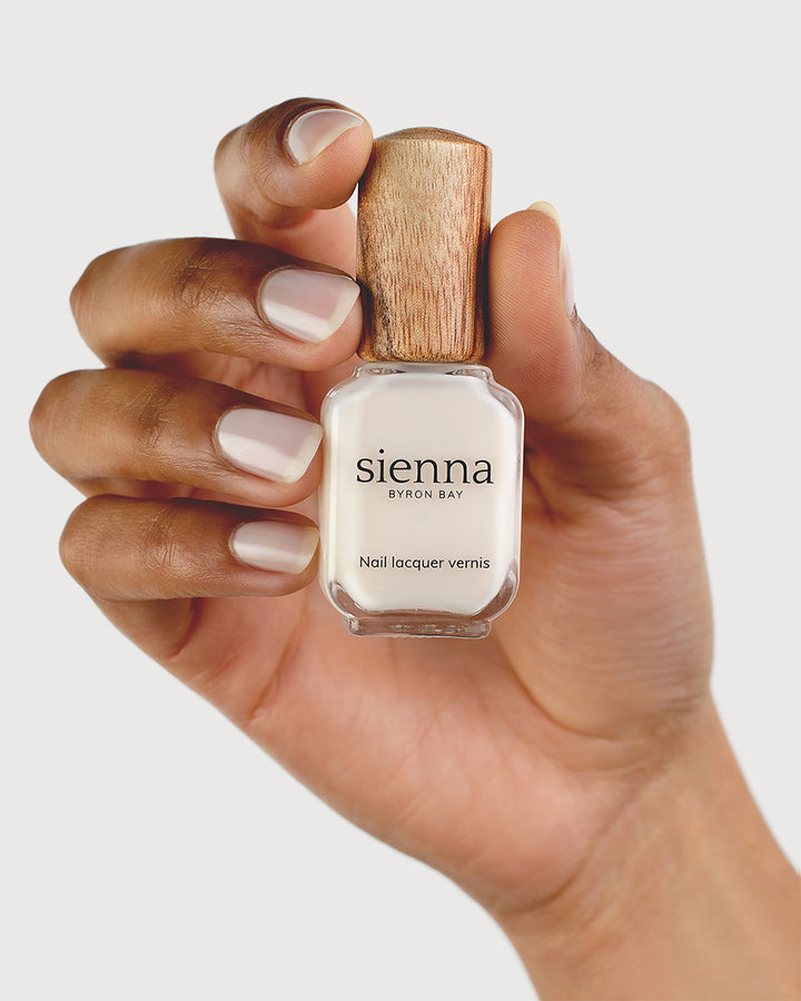 Milky Sheer White nail polish on medium skin tone with Sienna Bottle