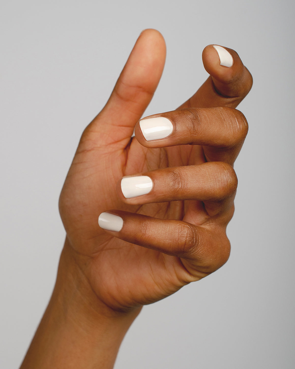 offwhite nail polish hand swatch on medium skin tone by sienna