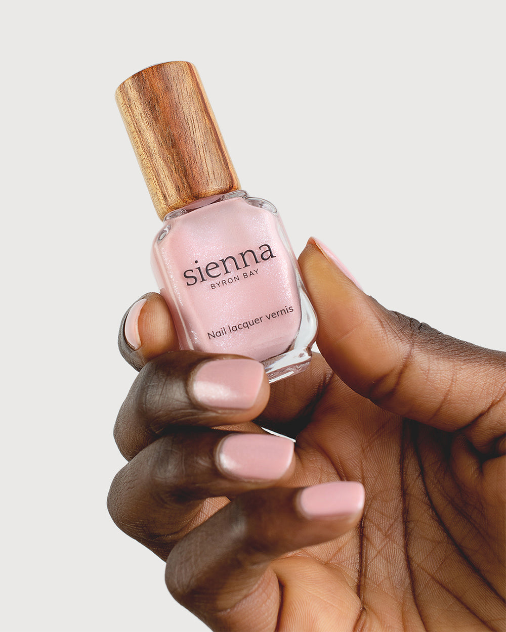 Shimmering Cherry Blossom Nail Polish on Dark Skin Tone with Sienna Bottle