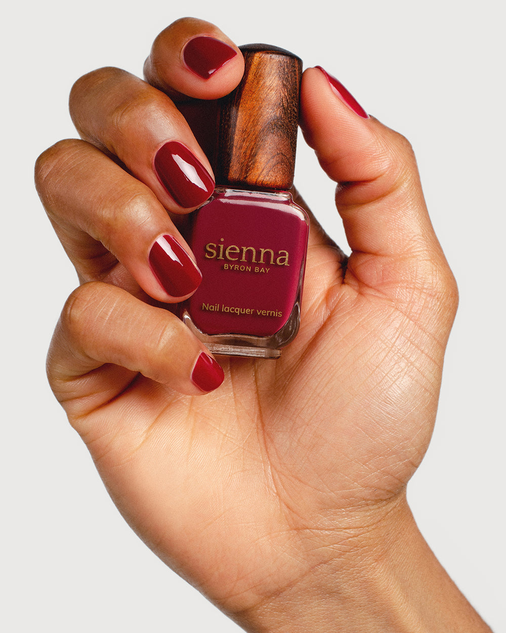 Plum red nail polish hand swatch on Medium skin tone with Sienna Bottle