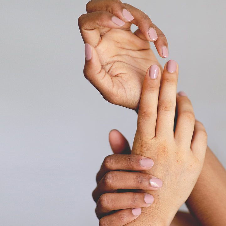 Medium brown and fair skin hands wearing Rosie nail polish by Sienna 