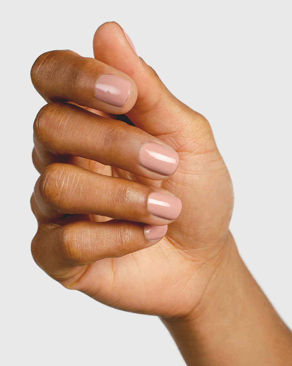 Medium skin tone hand wearing Sienna Byron Bay award winning natural nail colour Rosie. Nails are strong, and healthy and painted in crème Rosie pink.