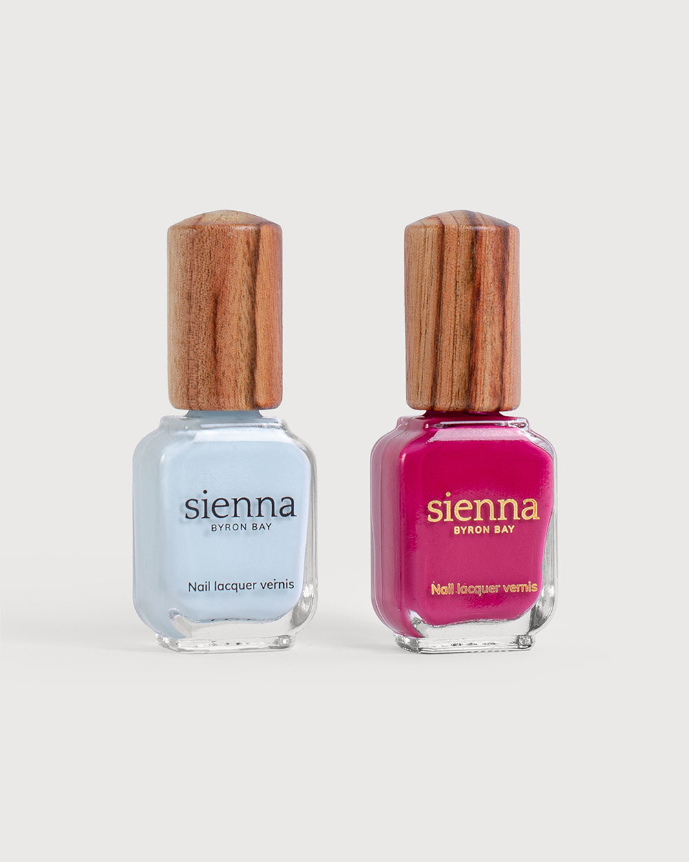 Pastel blue and fuschia pink nail polish glass bottles with timber caps