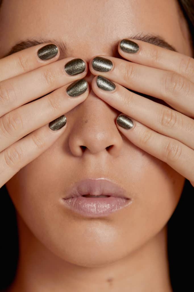two different skin tone model wearing crushed crystal nail polish by sienna on a beige background