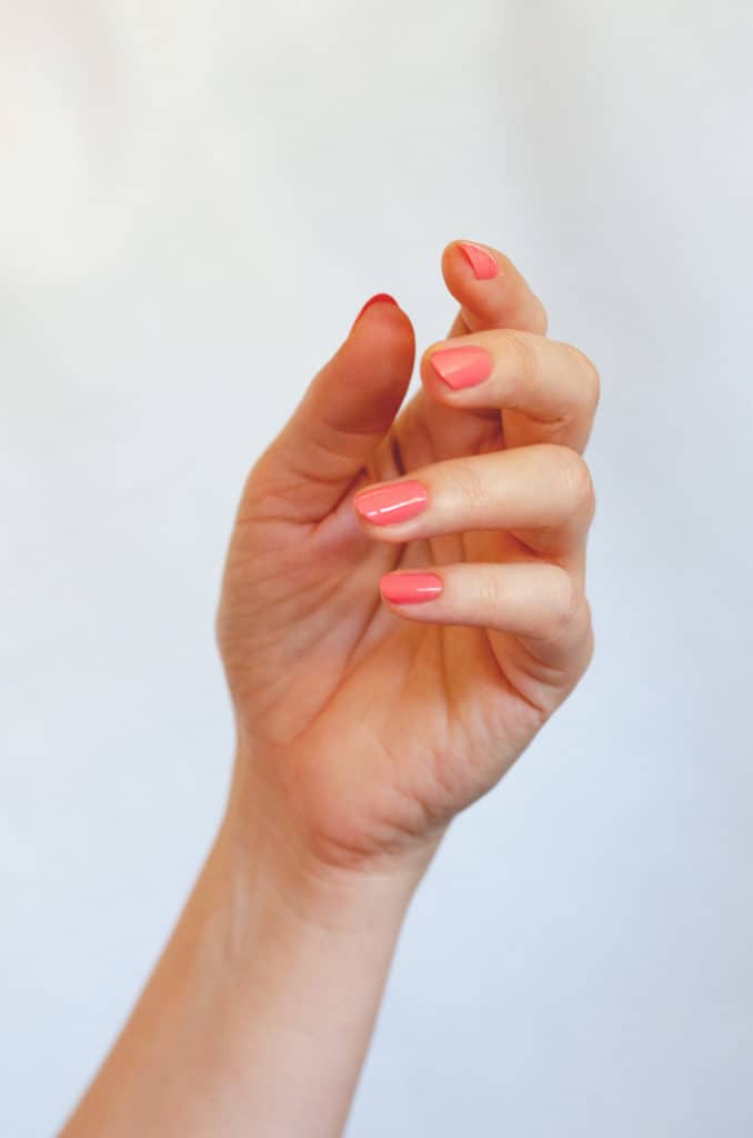 Apple red nail polish hand swatch on medium skin tone by sienna