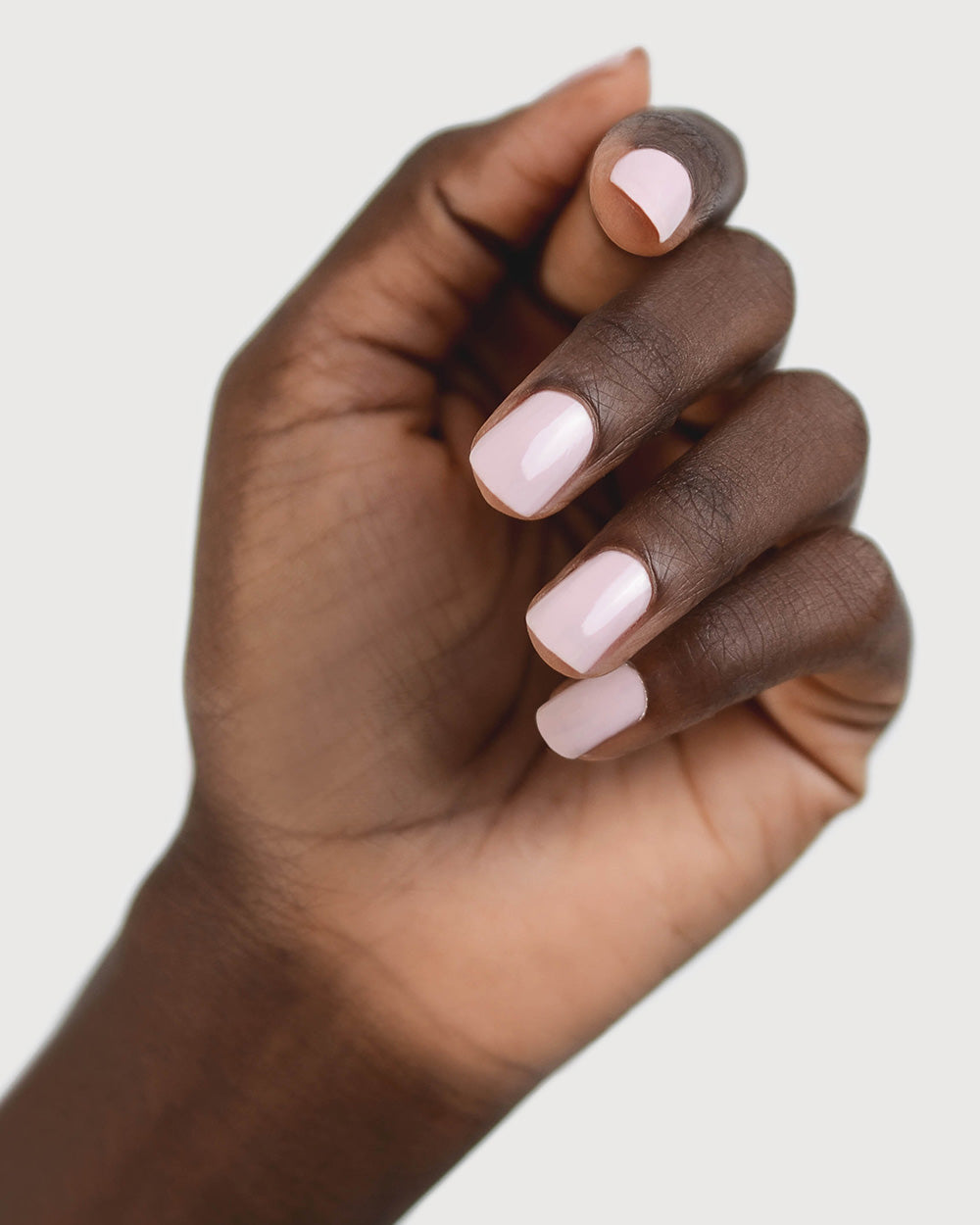 Tranquility Light Mauve Rose Crème nail polish by Sienna Byron Bay on dark skin tone hand.