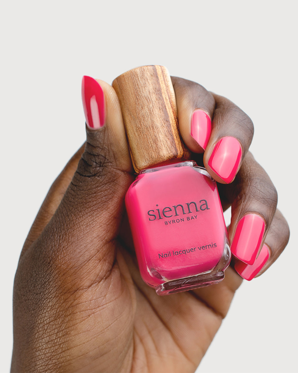 Blooming Fuchsia Petal Pink Nail Polish on Dark Skin Tone with Bottle