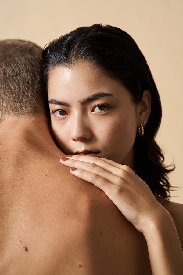 woman posing her head on man's shoulder and wearing red nail polish by sienna