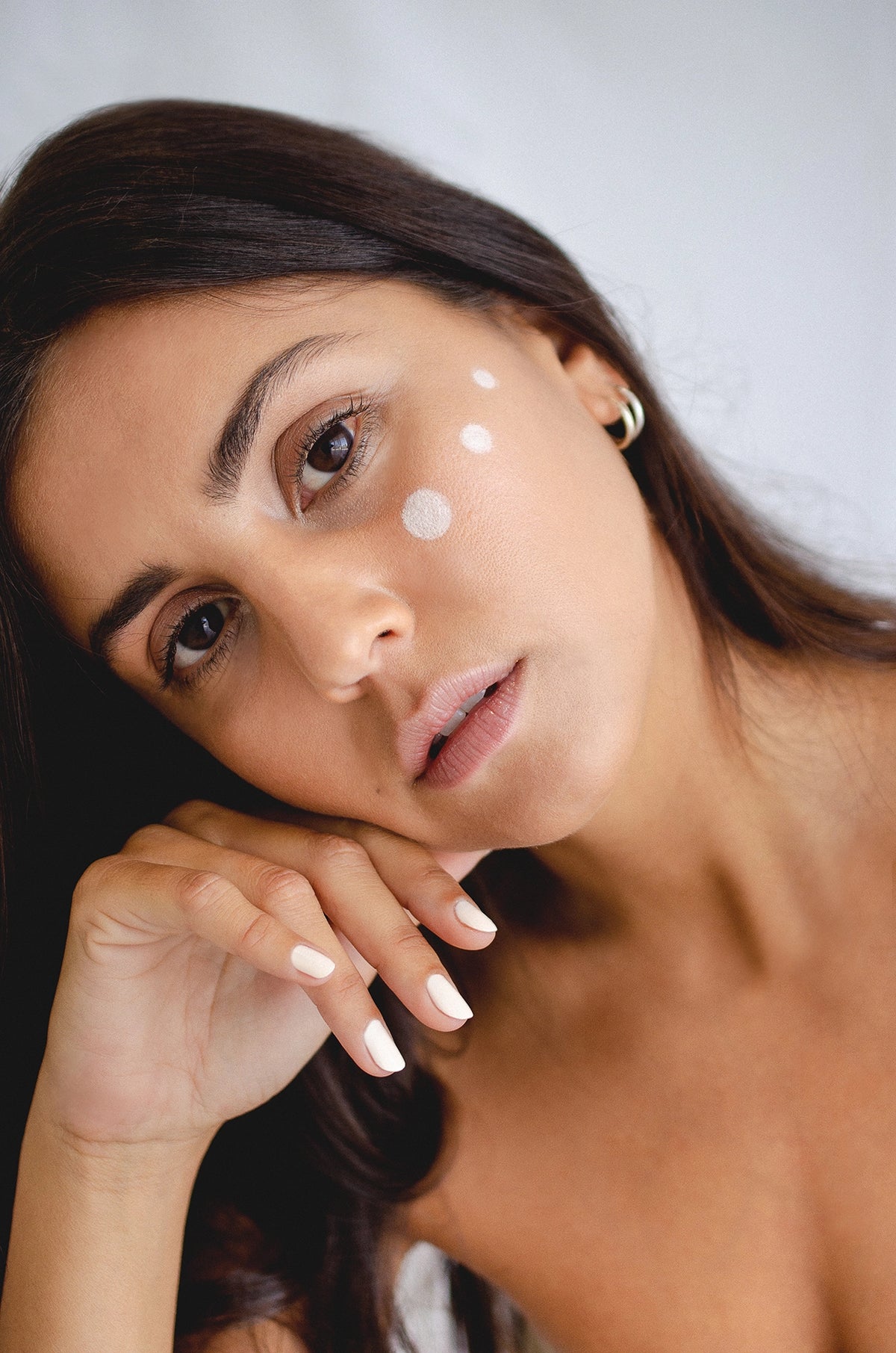 fair skin model portrait wearing white nail polish with white makeup