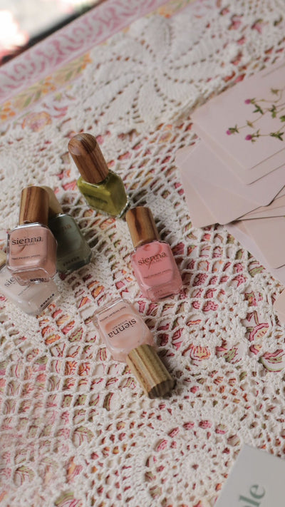 Set of nail polish bottles on a floral fabric background