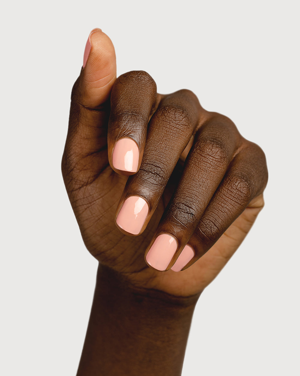 nude pink nail polish hand swatch on dark skin tone