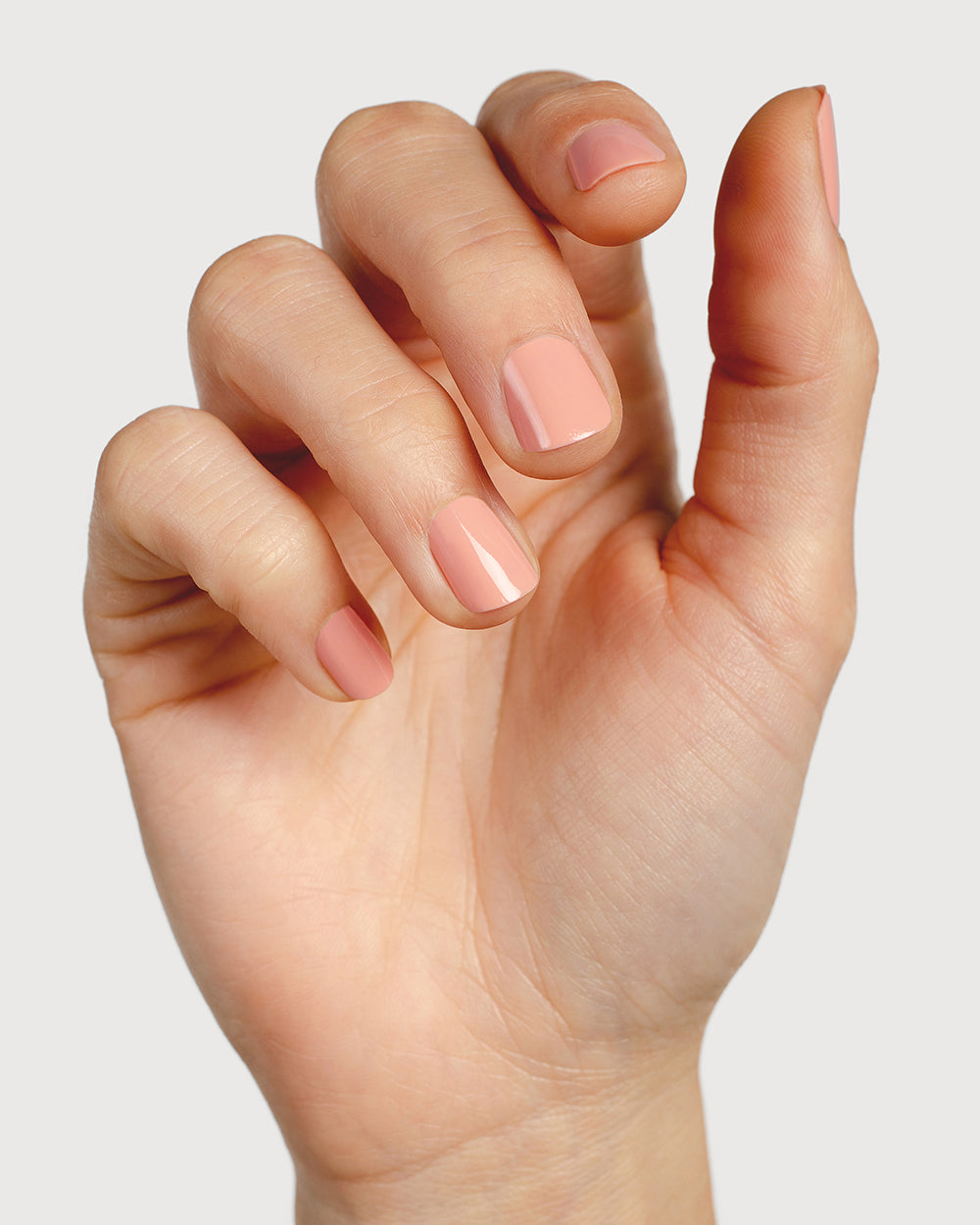 nude pink nail polish hand swatch on fair skin tone