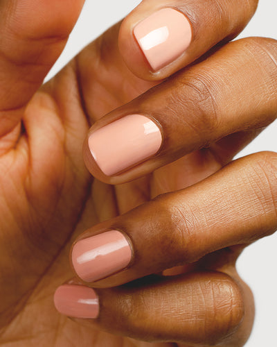 nude pink nail polish hand swatch on medium skin tone up close