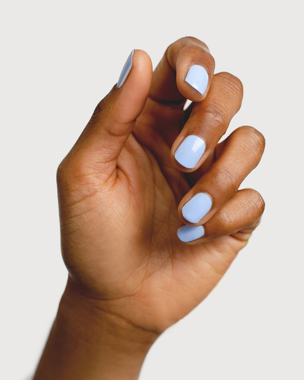 baby blue nail polish hand swatch on medium skin tone