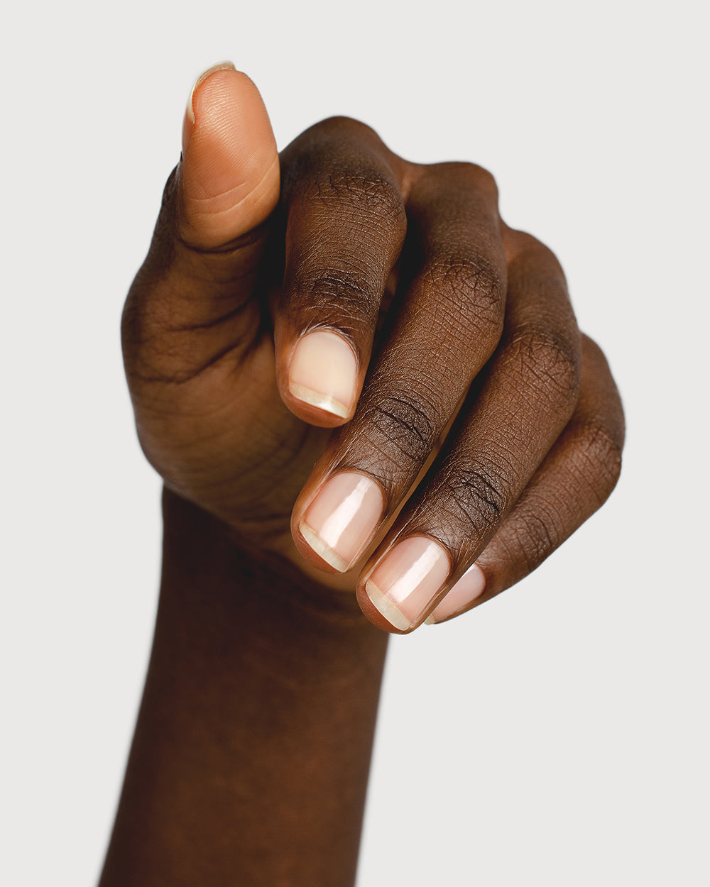 transparent base and top coat hand swatch on dark skin tone 