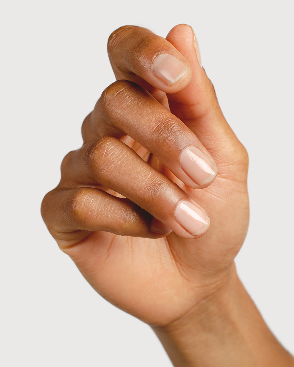 clear base coat nail polish hand swatch on medium skin tone