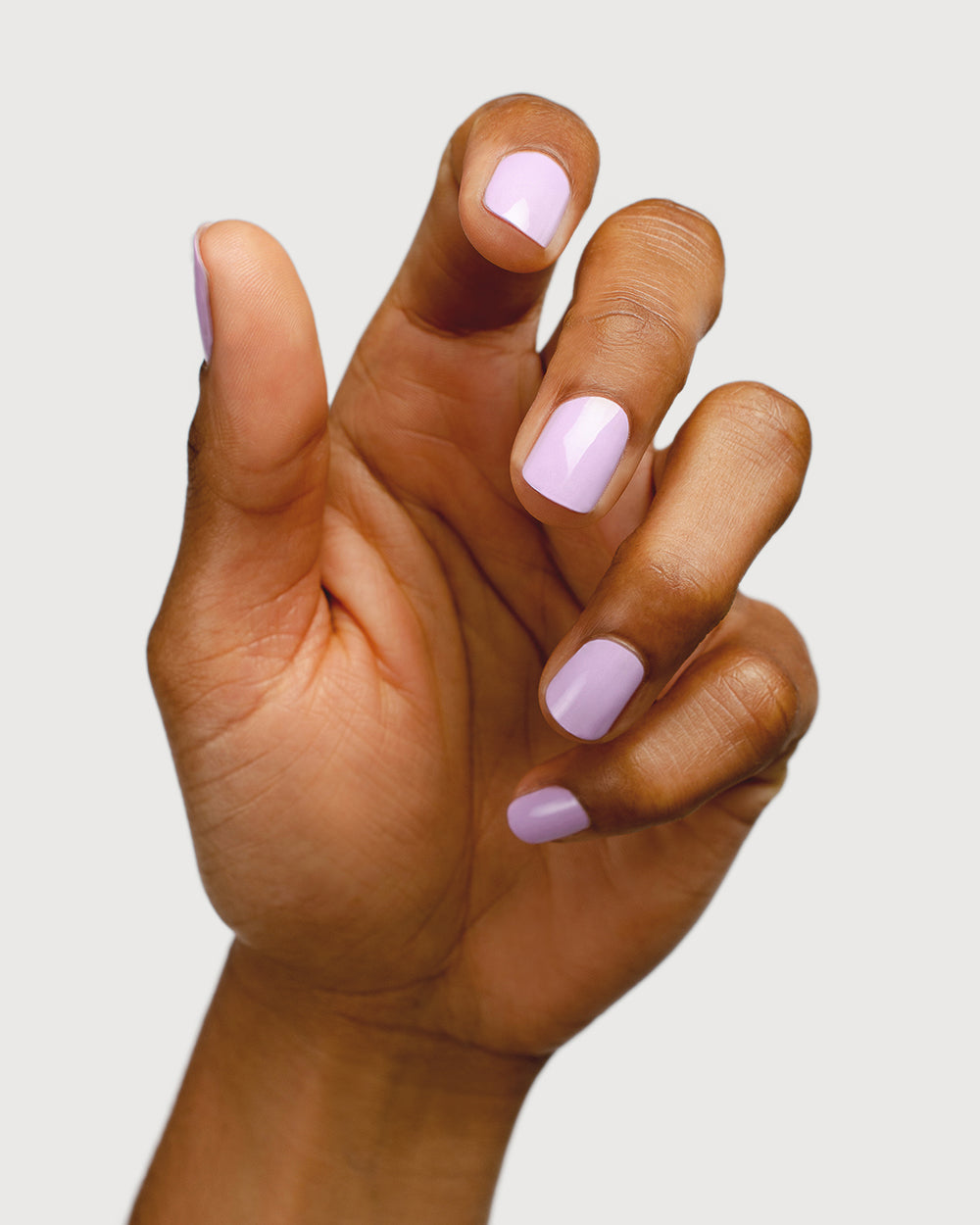 lilac purple nail polish hand swatch on medium skin tone