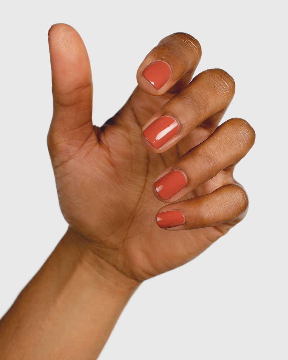 terracotta nail polish hand swatch on medium skin tone