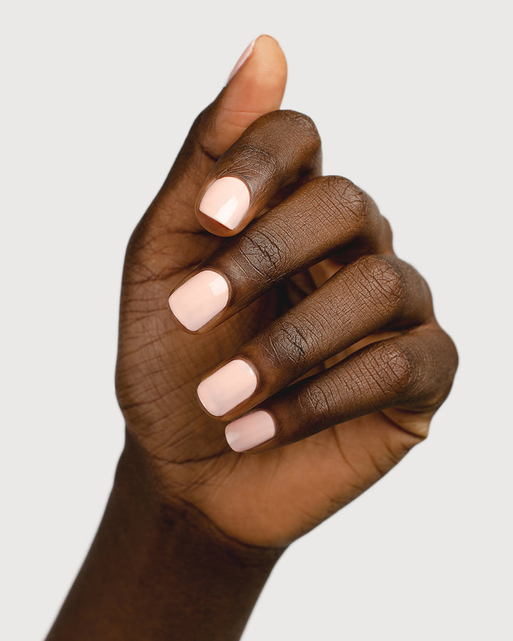 pastel pink nail polish hand swatch on dark skin tone