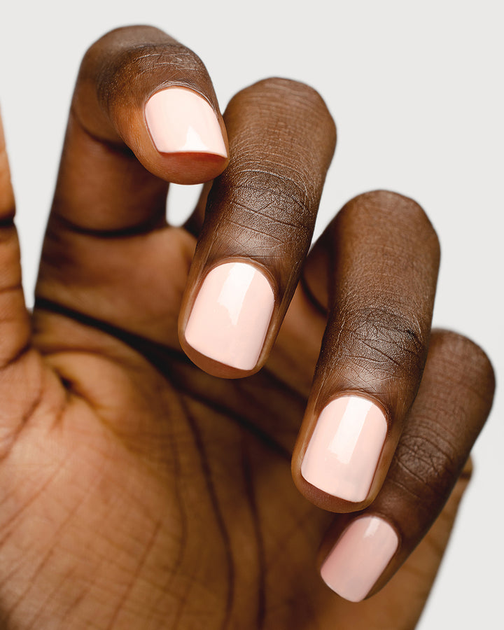 pastel pink nail polish hand swatch on dark skin tone up close