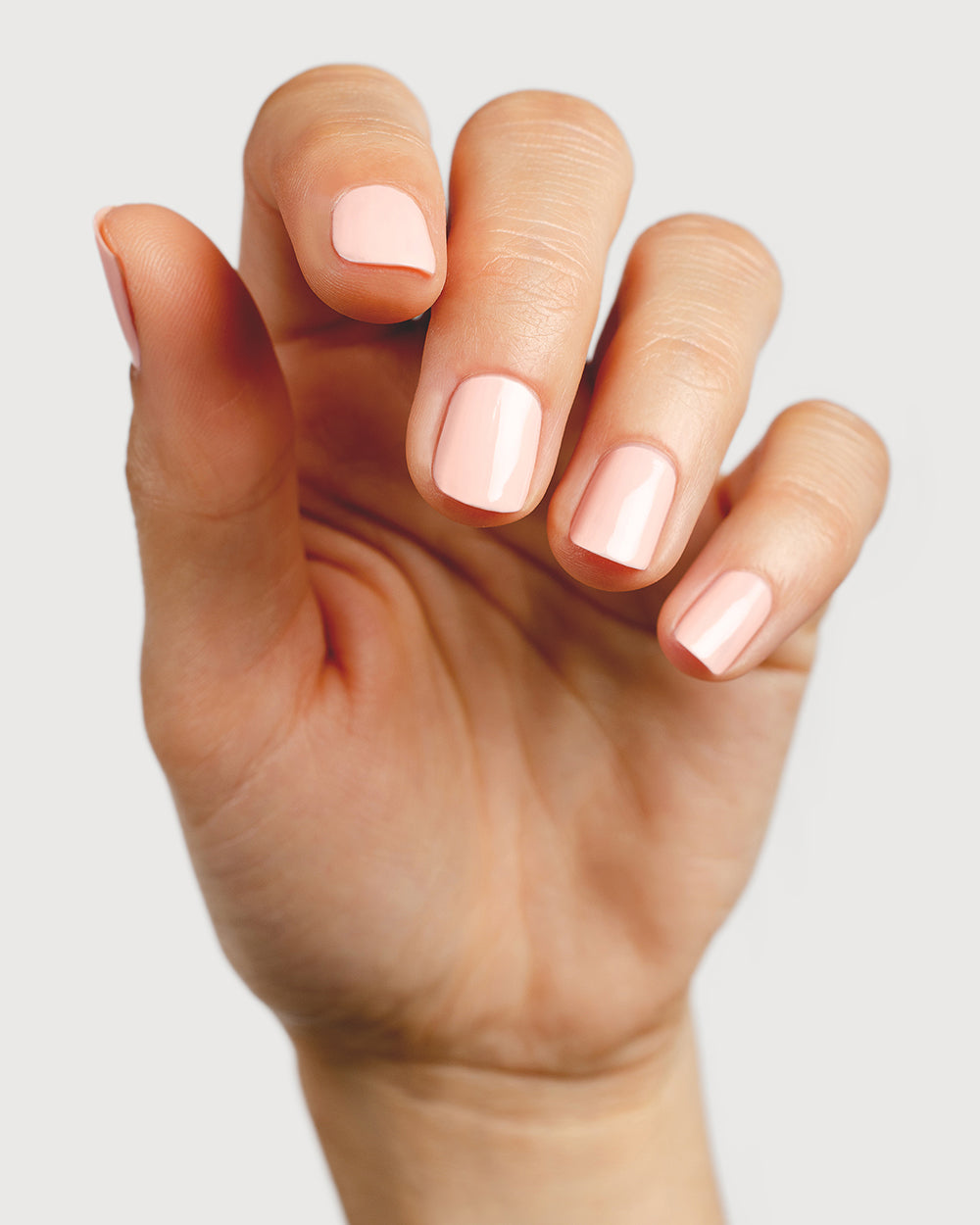 pastel pink nail polish hand swatch on fair skin tone